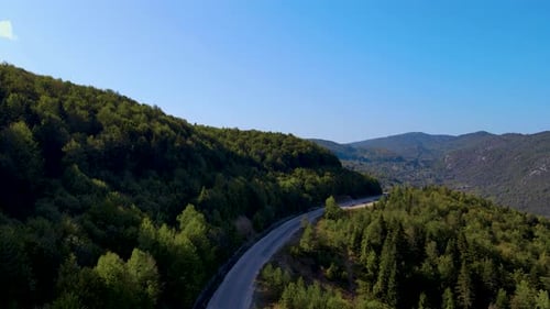 Montagnes verdoyantes escarpées, forêt profonde et route de montagne, belle vallée