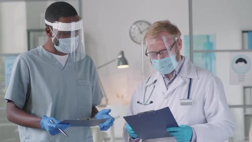 Medical Professionals Consult Wearing Masks and Shields