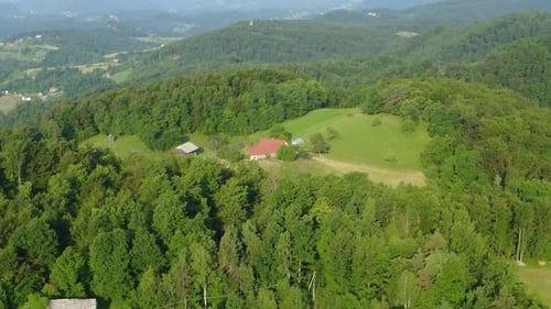 Big family house with wooden barn in the middle of green forest and surrounded with meadows. Aerial