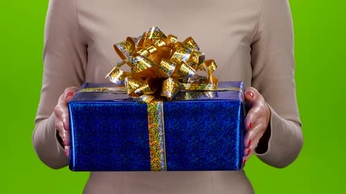 Woman Holding out Blue Gift with Gold Bow