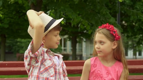 Brother and Sister Smiling on Park Bench