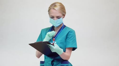 Medical Professional Writes on Clipboard, Holds Blood Vial