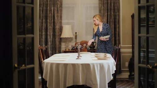 Woman Setting Elegant Dining Room Table for Dinner