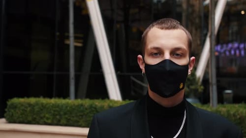 Young Caucasian Man Walking on Urban City Business Office and Wearing Medical Mask for Prevention