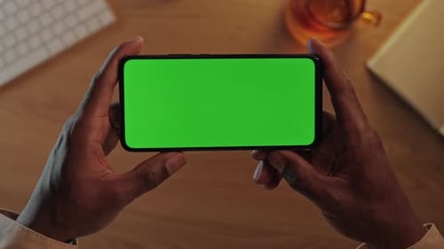 Close Up of Black Person Using Mobile with Chroma Key Screen