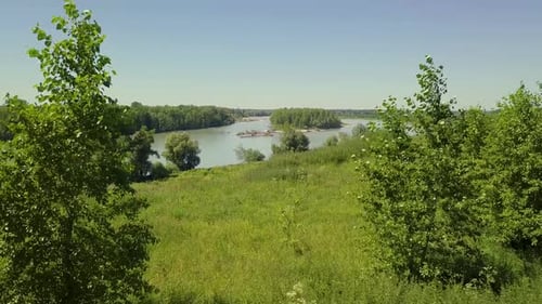 Aerial: Flying Through Deciduous Trees, Cliff. View of Mountain River, Islands and Forest.