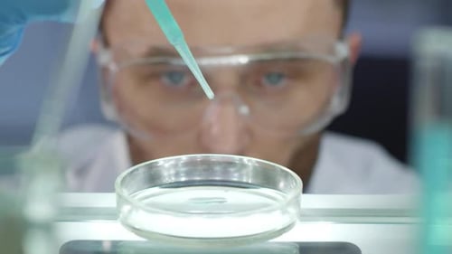 Scientist Using Pipette with Petri Dish in Lab