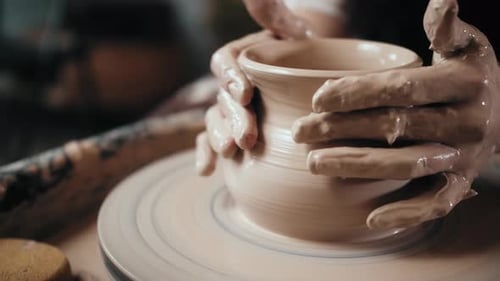 Man Potter Working on Potters Wheel Making Ceramic Pot From Clay in Pottery Workshop