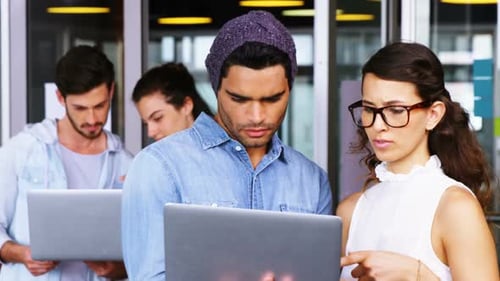 Team Using Laptops for Collaborative Work in Office