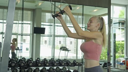 Woman Exercising on Cable Machine in Gym