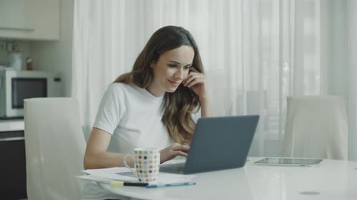 Woman Working on Laptop at Home at Table