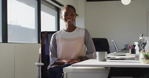 Smiling Woman Sitting at Desk in Office
