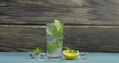 Clear Water in Glass with Green Mint Leaves and Ice Cubes