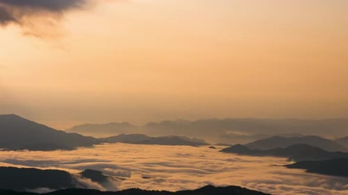 Majestic Mountains Covered in Clouds During Sunrise