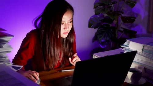 Asian businesswoman working on laptop computer at home office. work overtime doing deadline project