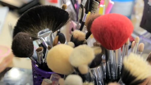 Makeup Brushes in Holder and Cosmetics Isolated on White