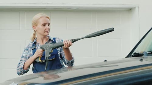 Portrait of an Active Woman Washing Her Car Near the Garage