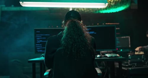 People Working on Computers in Dark Modern Workspace