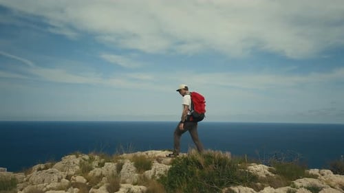 Man with Backpack Hike on Ridge of Mountain Cliff