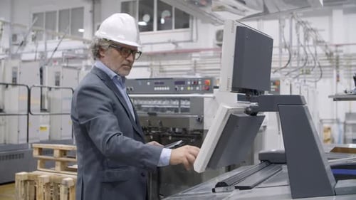 Old Male Factory Engineer Checking Industrial Machine