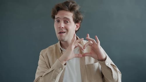 Young Adult Makes Heart Shape with Hands
