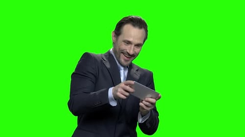 Man in Suit Playing Smartphone Game on Green Screen