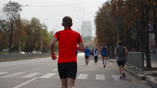 Man Running Marathon with Smartphone in Hand