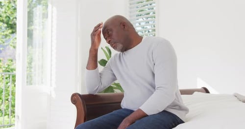 Tired african american senior man having headache