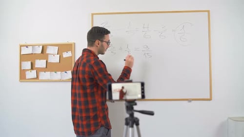 Male Math Teacher Explains Fraction on Whiteboard
