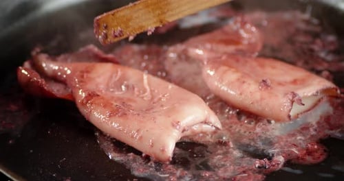 Close Up Squid Cooking in Pan with Chopsticks