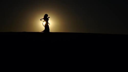 Woman Dancing with Scarf Silhouette in Desert Sunset