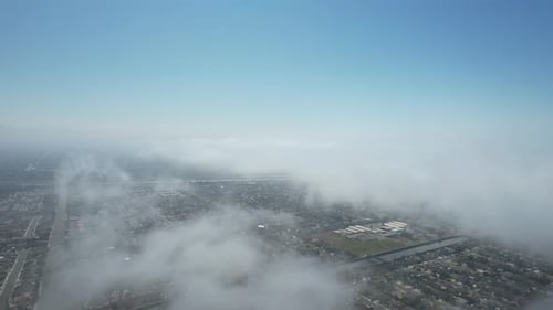 Aerial View of City Underneath Layer of Clouds