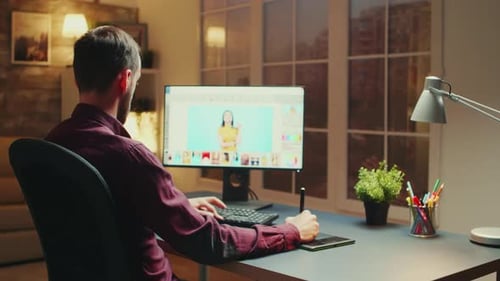 Man Edits Photos at Desk with Digital Tablet