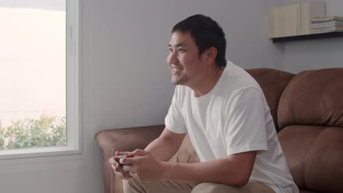 Man Playing Video Games at Home on Couch