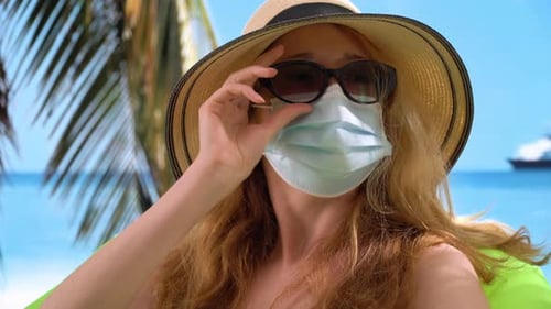 Woman Wearing Protective Medical Mask on the Resort Beach