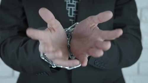 Man with Hands in Chains, Dressed in Business Suit
