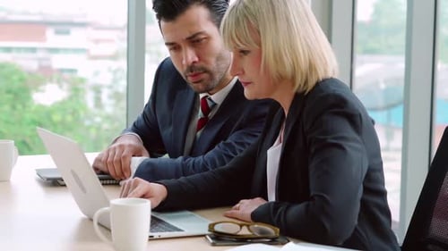 Two Business People Talk Project Strategy at Office