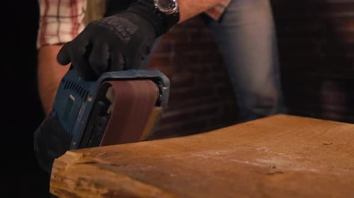 Woodworker schleift Kanten von altem Holz mit Poliermaschine in einer Fabrik