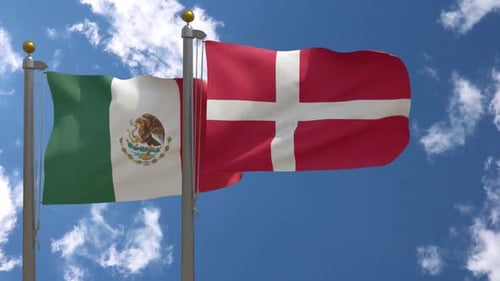Flags of Mexico and Denmark Waving Against Blue Sky