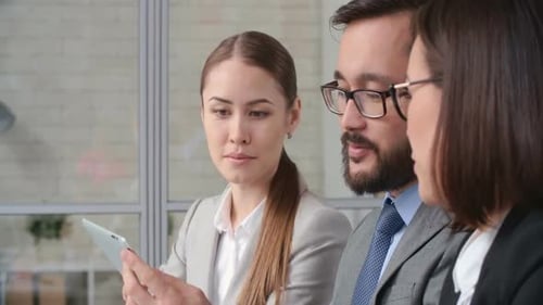 Business Team Collaborating on Tablet Device in Office