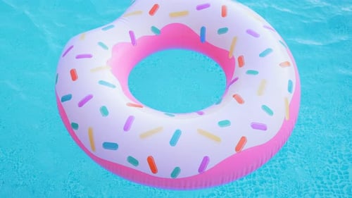 Anel de donut inflável rosa flutuando na piscina azul clara