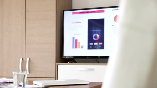 Revealing Shot Company Sales Report on Big Screen TV in Empty Conference Room