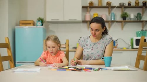 Woman and Girl Drawing Together at Kitchen Table