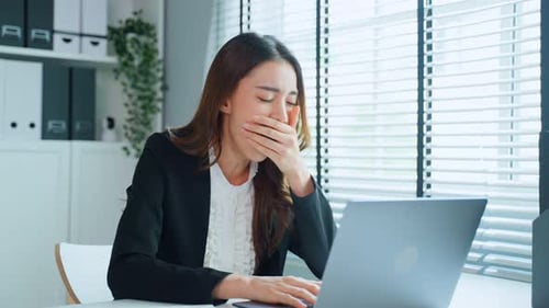 Tired Woman Working at Laptop in Office