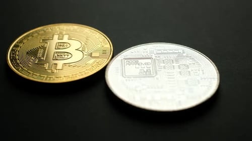 Gold and Silver Bitcoins on a Black Surface