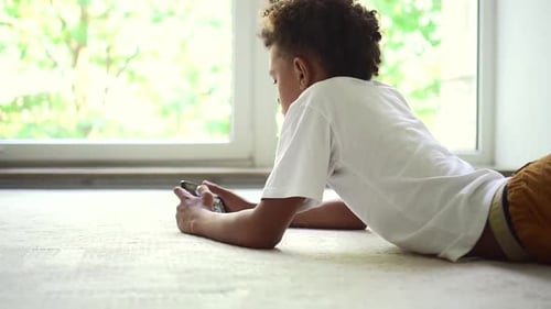 Young Boy Using Mobile Device Indoors