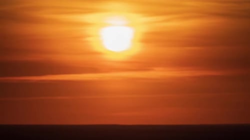 Timelapse of the Golden Sunset. The Sun Moves Through the Clouds To the Horizon