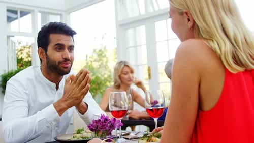 Couple interacting while having red wine in restaurant