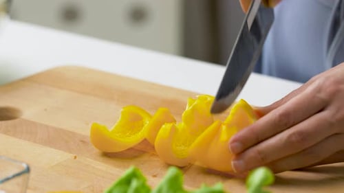 Hands Dicing Yellow Bell Pepper with Knife