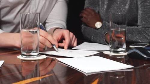 Businessmen And Businesswomen Working Together On A Document.